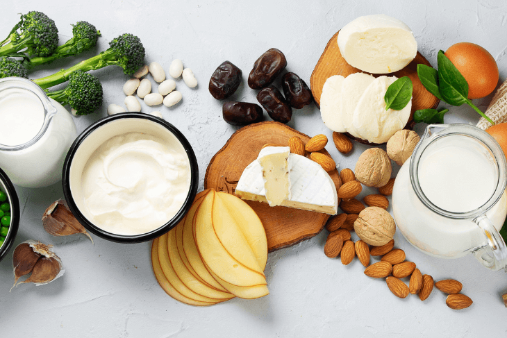 A spread of calcium-rich foods including cheese, yogurt, almonds, milk and broccoli