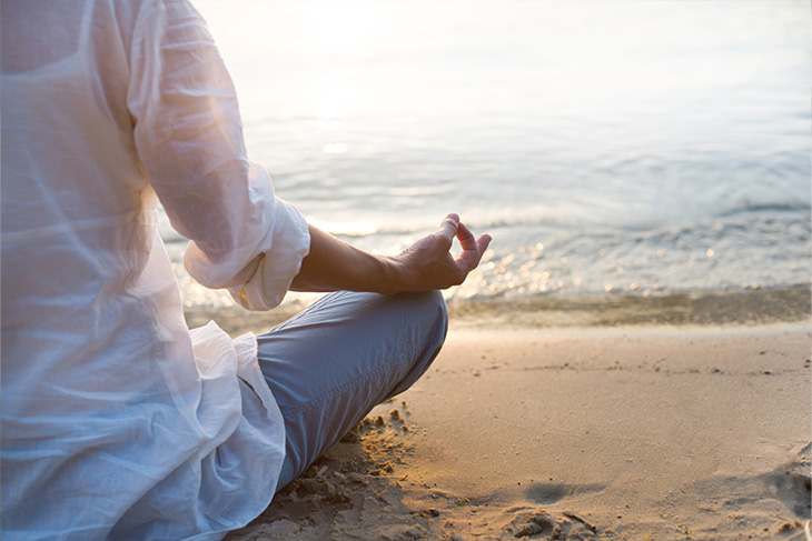 Woman meditating at the beach.