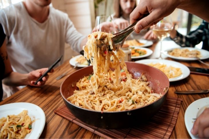 A plate of creamy pasta on a wooden pasta.
