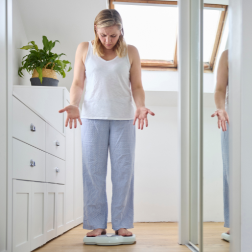Woman on scales questioning the weight reading