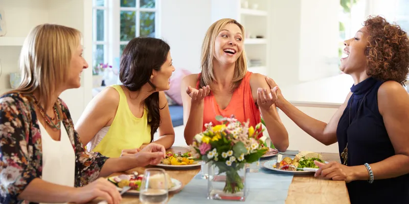 Four women laughing and having lunch together