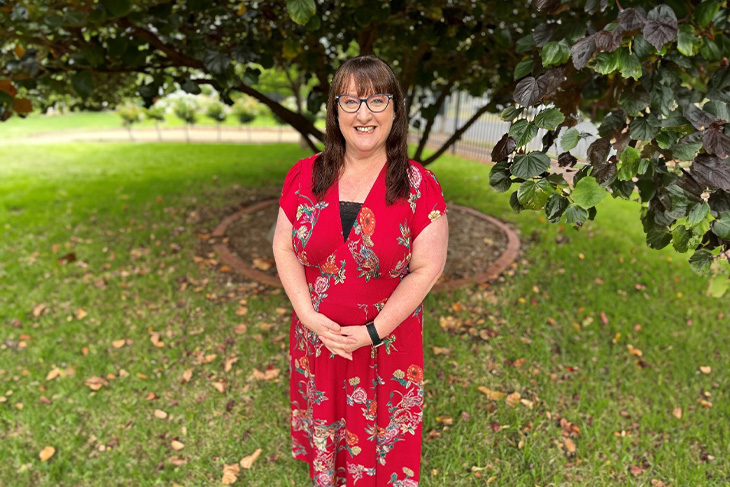 Jayne's after photo taken outdoors, wearing a floral dress.